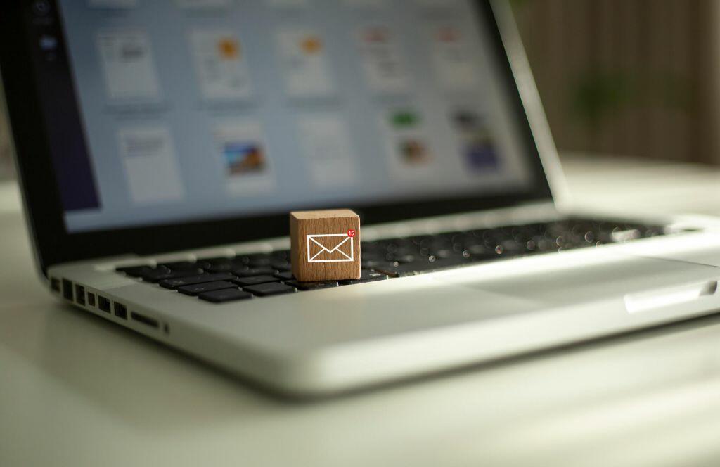 Wooden box with email logo sitting on laptop.