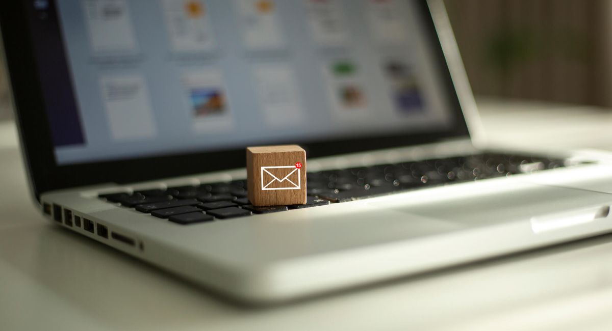 Wooden box with email logo sitting on laptop.