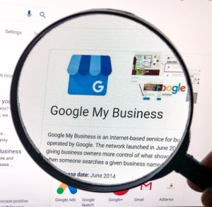 Person magnifying the Google My Business description and logo.