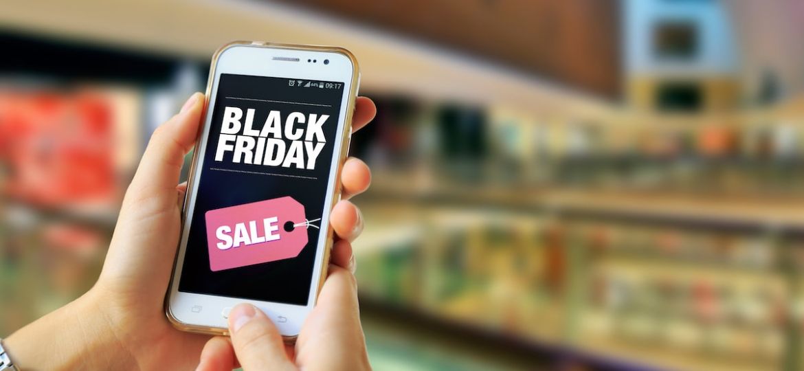 person holding a smartphone with the text "Black Friday Sale"