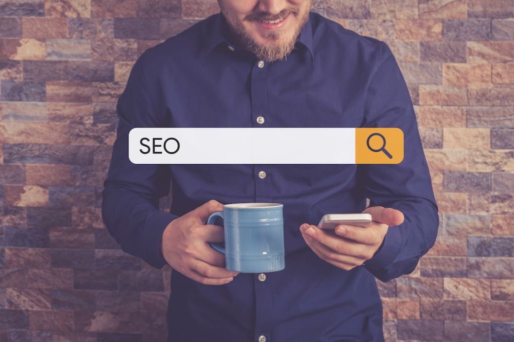 Man looks at his phone, searching the term SEO