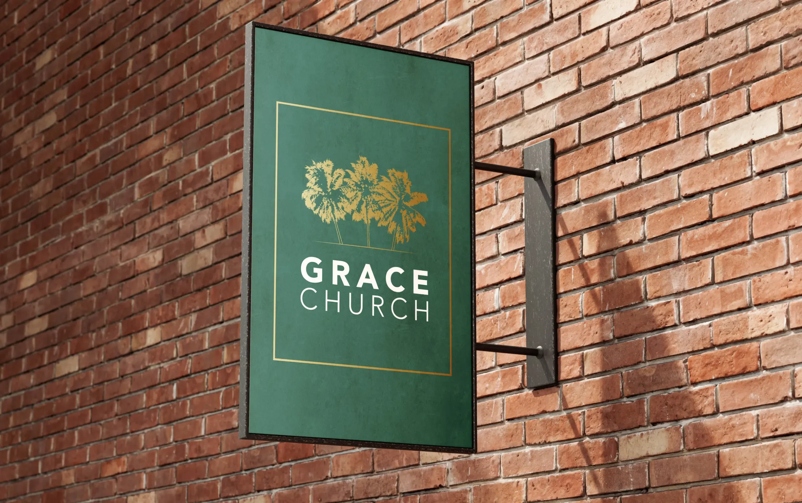 Green sign with trees and Grace Church logo on a red brick wall.