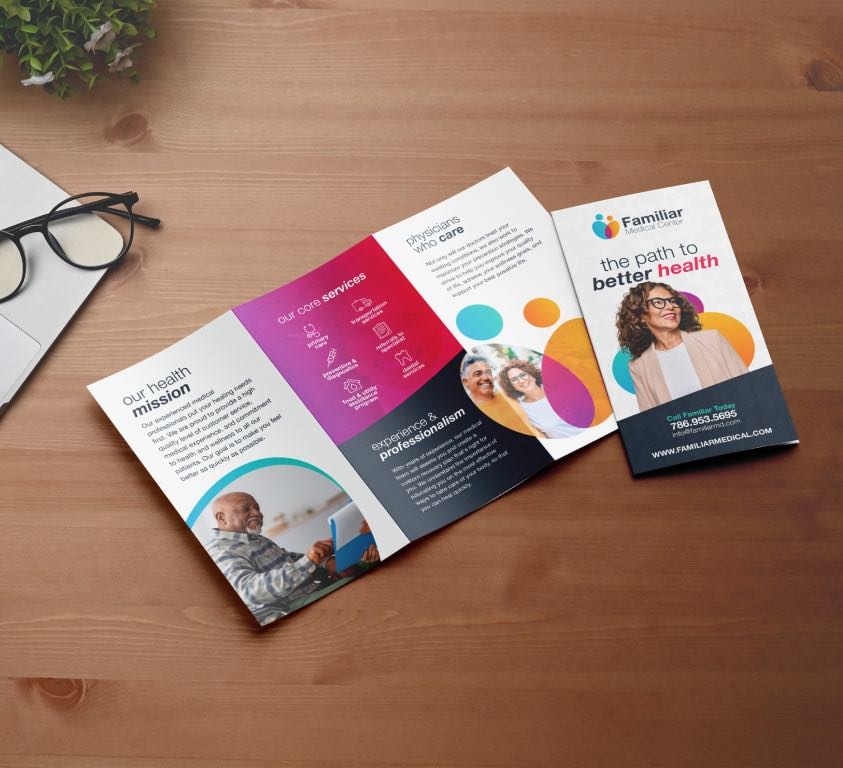 Colorful health brochure with eyeglasses on a wooden desk.