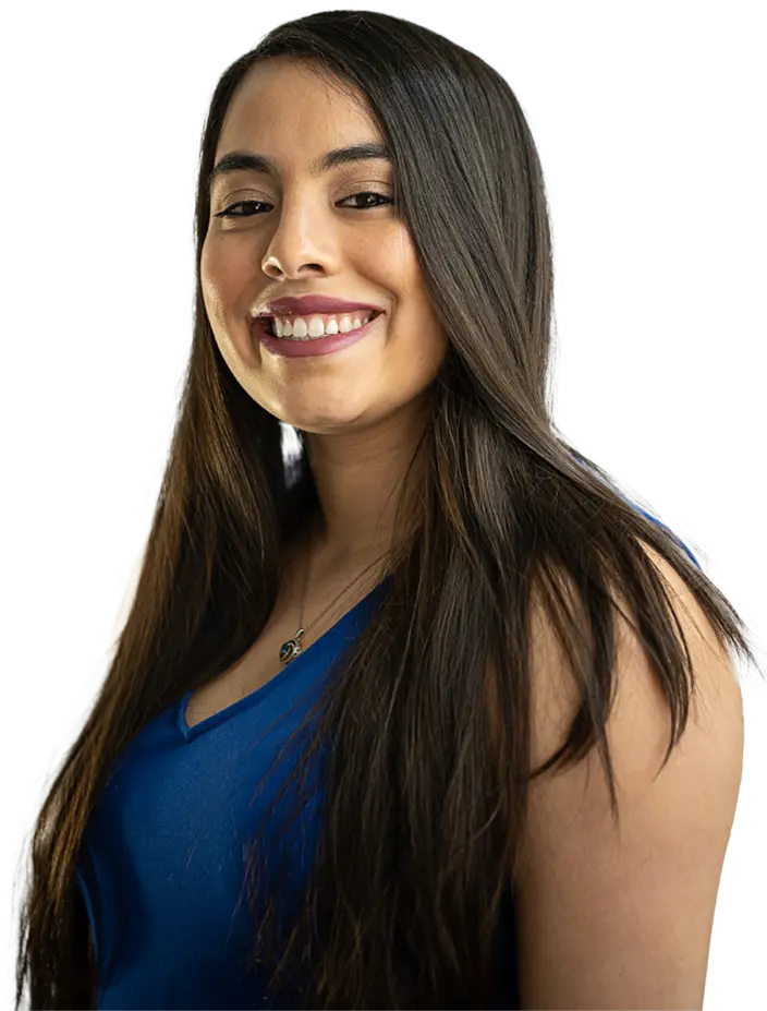 Smiling woman with long hair in a blue blouse, posing confidently.