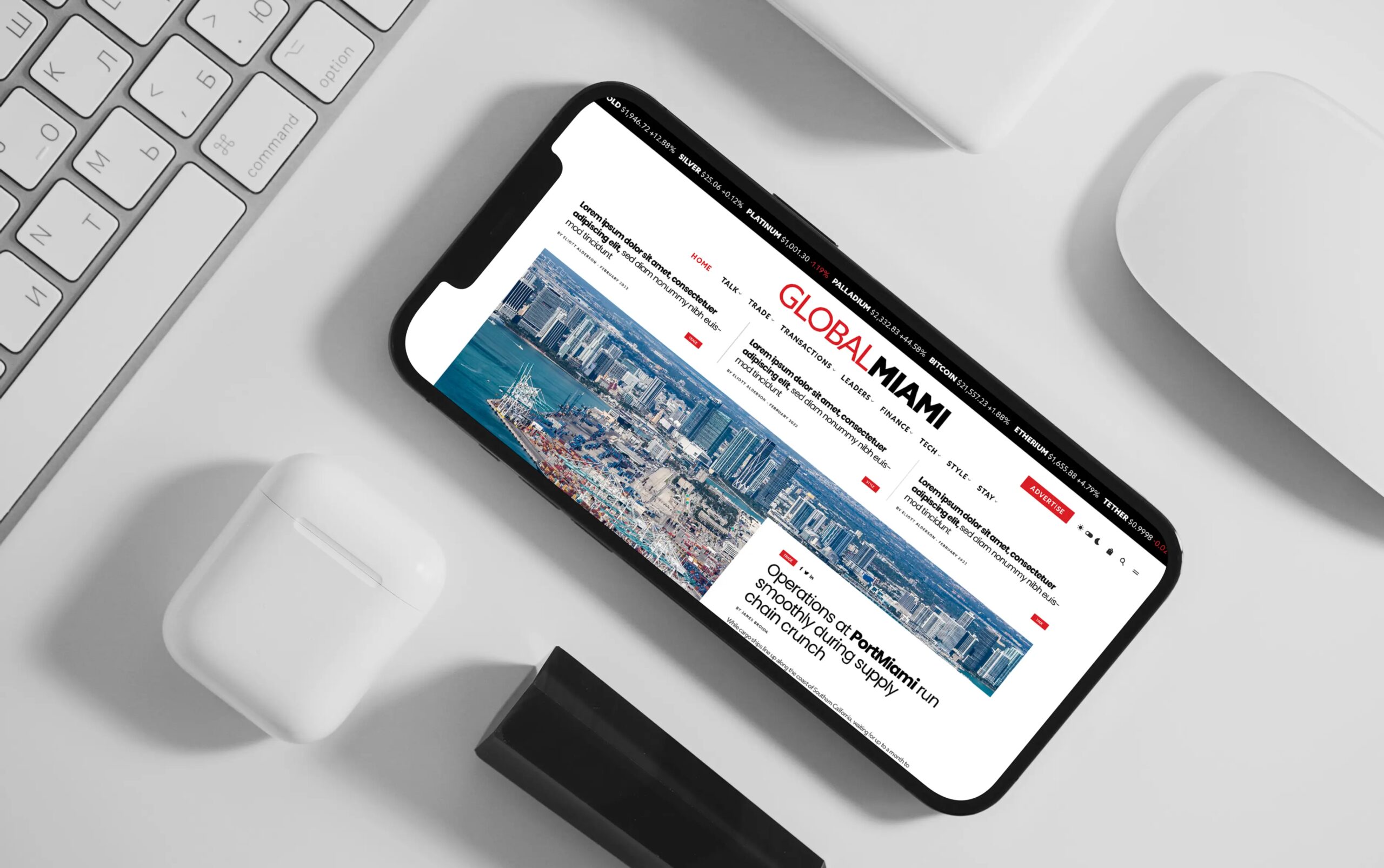 Smartphone displaying a website on a desk alongside a keyboard and earphones.
