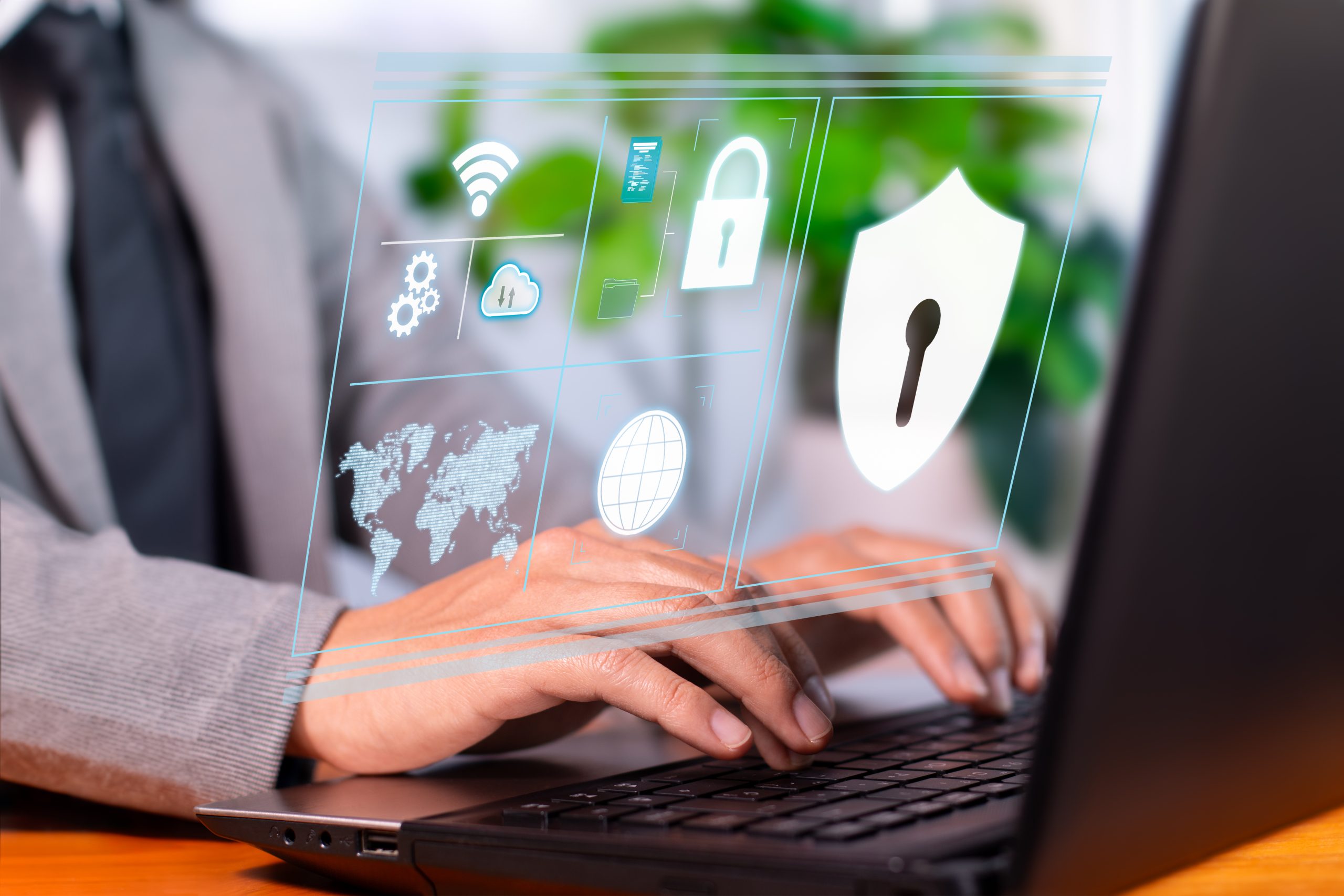 Person using laptop with holographic cybersecurity icons