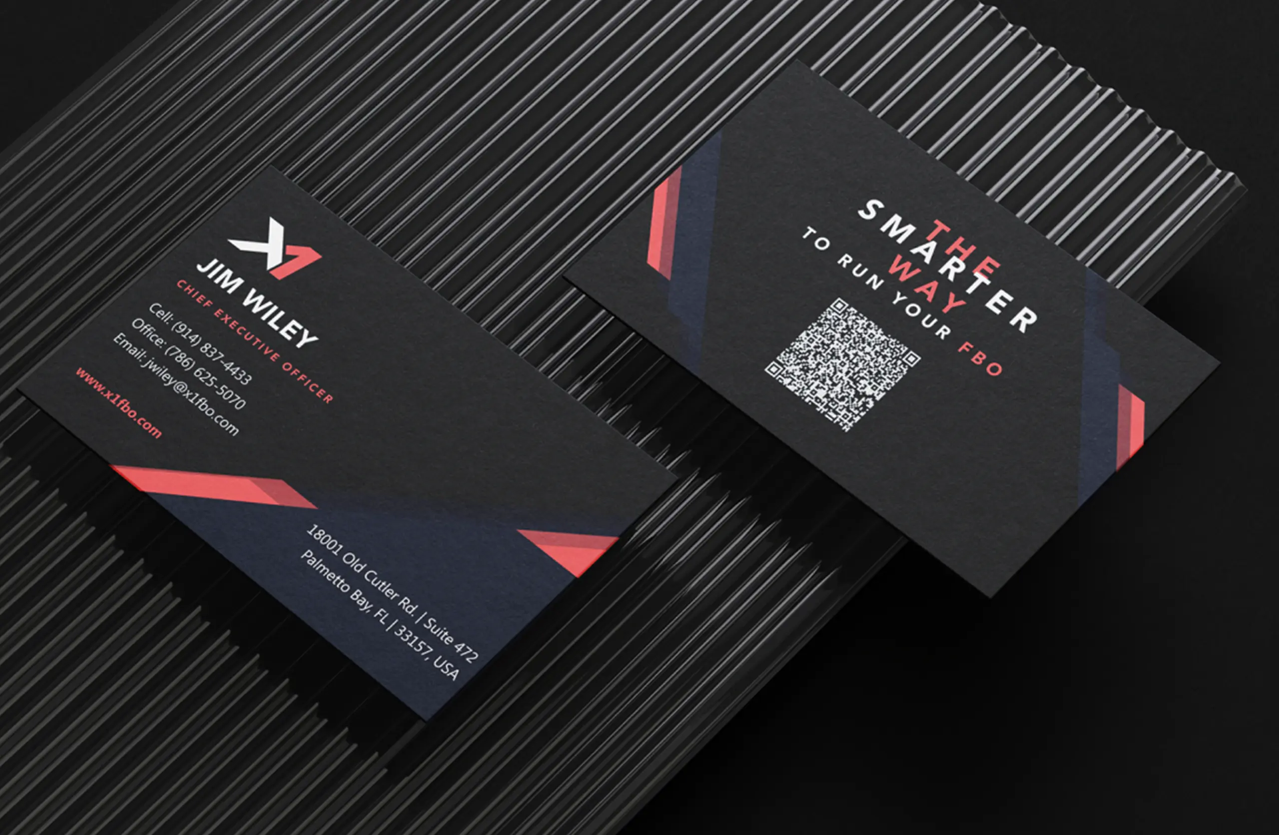 Sleek black business cards with modern design and QR code on dark textured surface.
