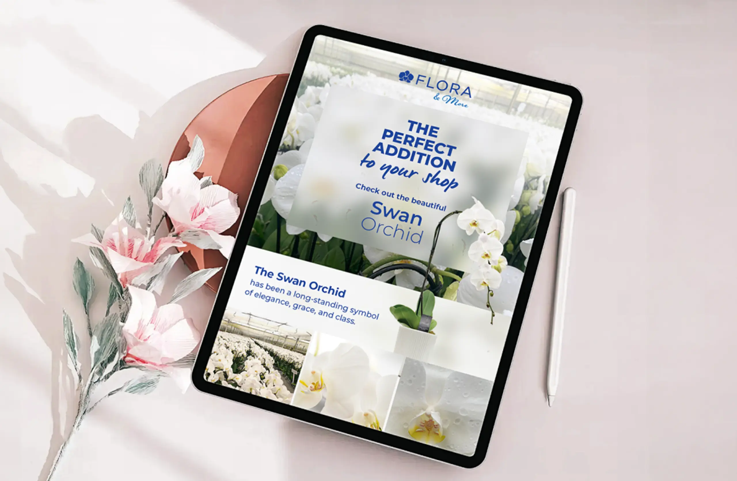 Digital tablet displaying a floral-themed magazine with orchids, complemented by fresh pink and white flowers beside.