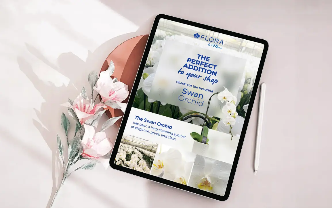 Tablet displaying a digital floral catalog, surrounded by pink flowers and a stylus.