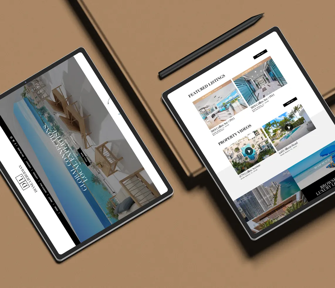 Two tablets displaying a luxurious property website on a sleek brown desk.