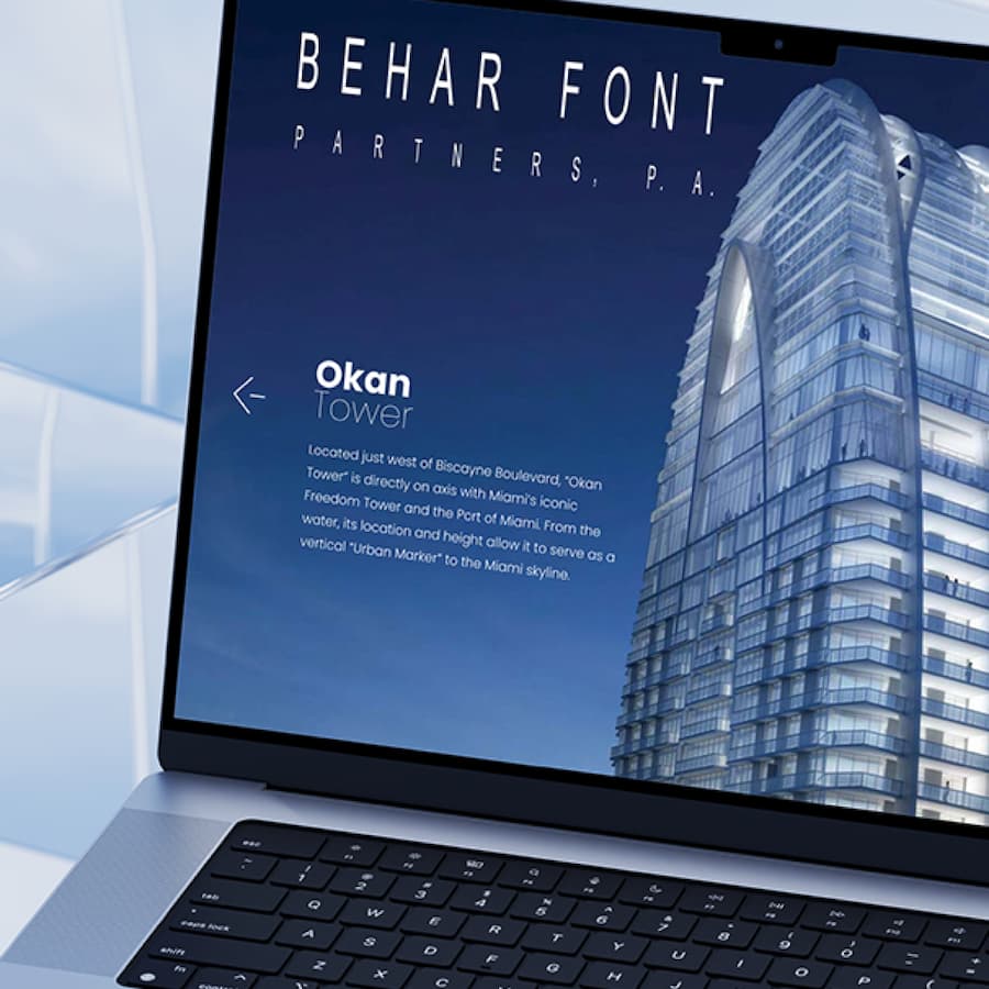 Laptop displaying an architectural design with a sleek, modern skyscraper and bold text.