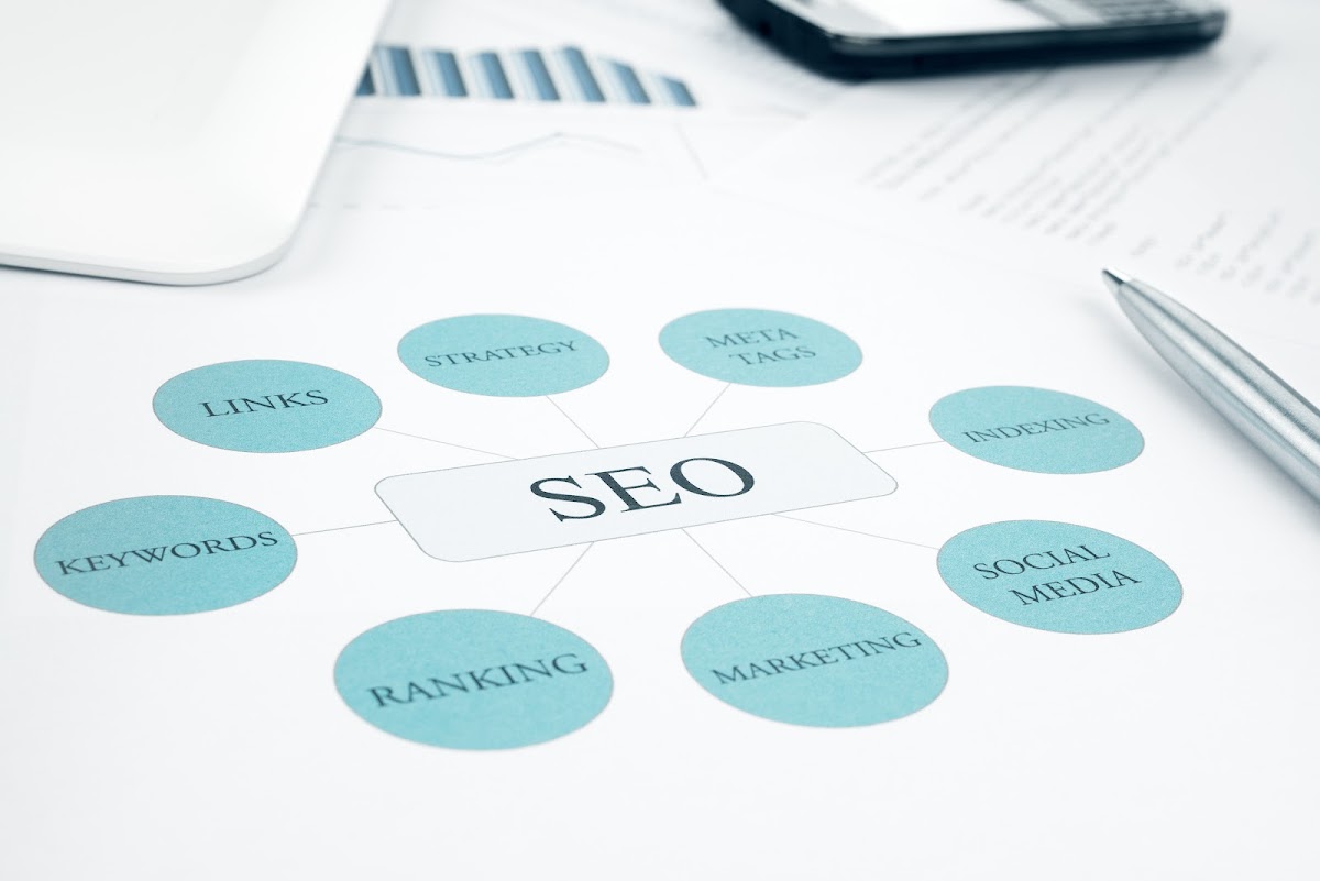 SEO flowchart with blue circles on paper next to a pen and digital tablet.