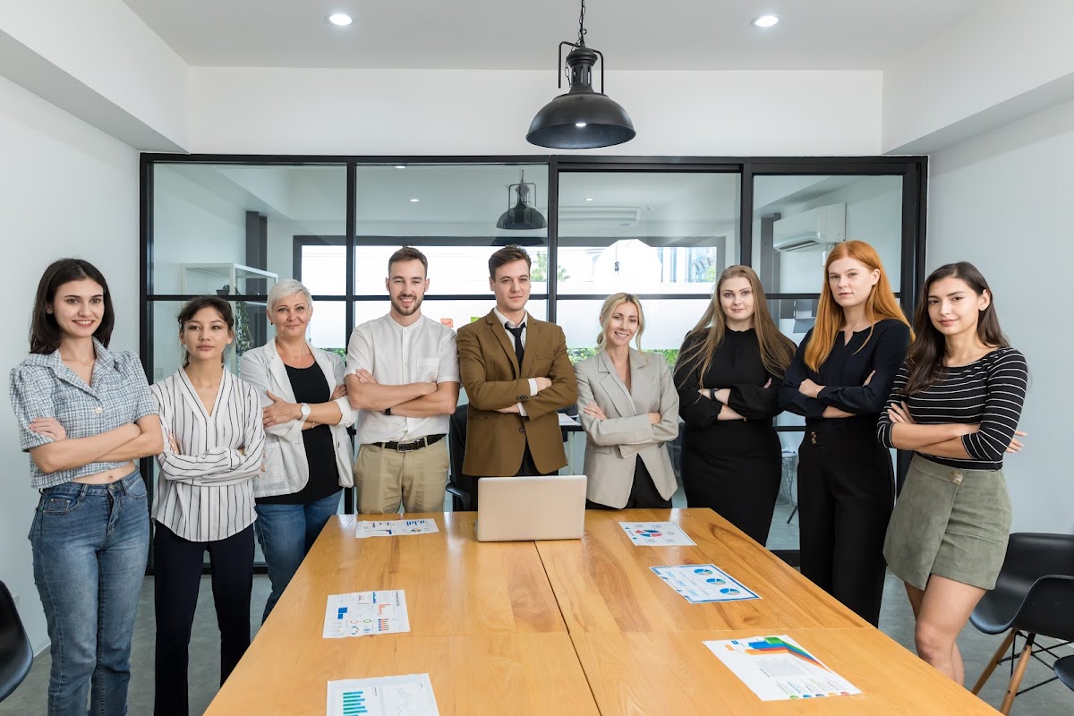 Diverse team of professionals stands confidently in a modern conference room.