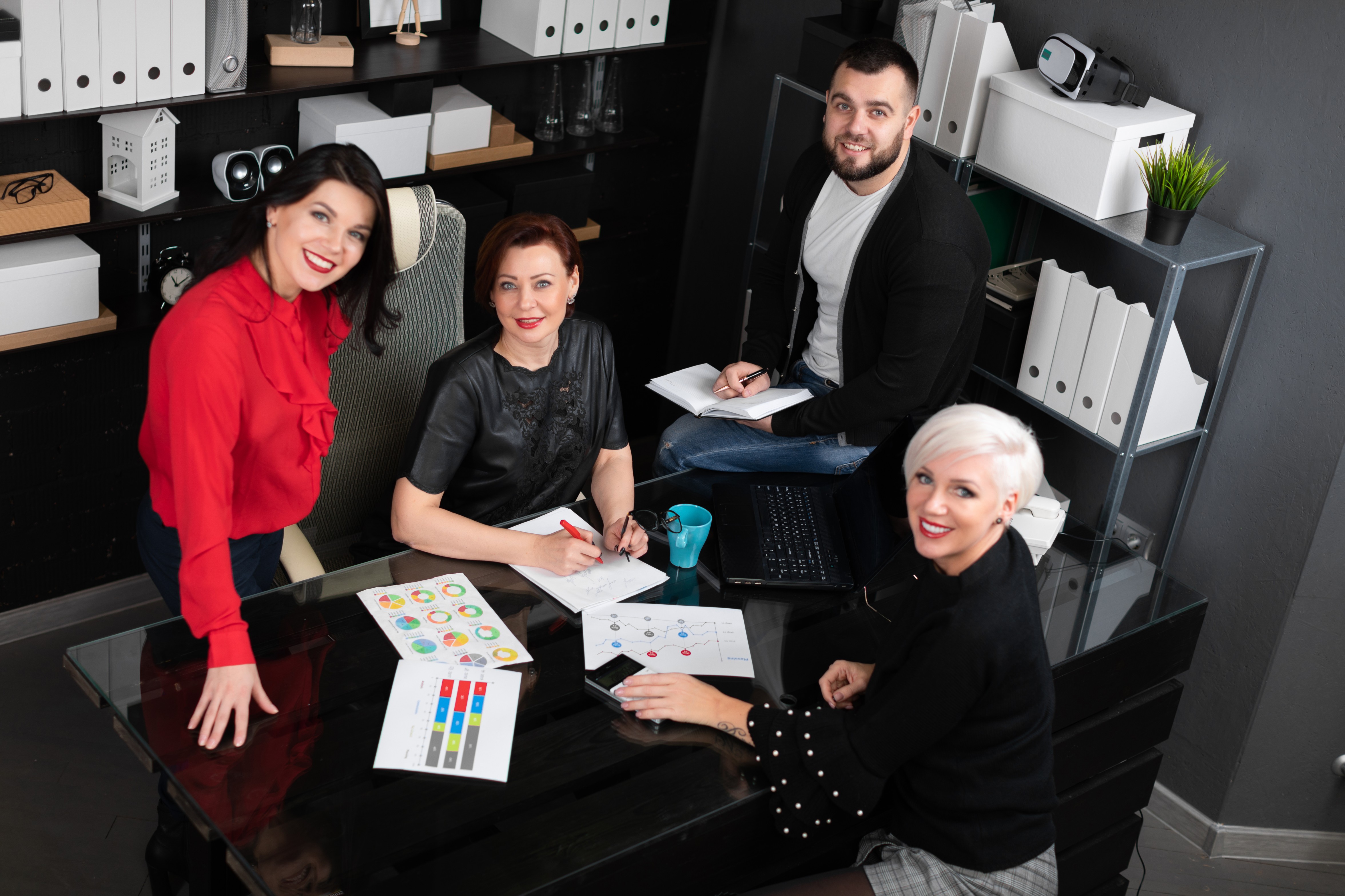 Diverse team collaborating on a project at a modern office desk.
